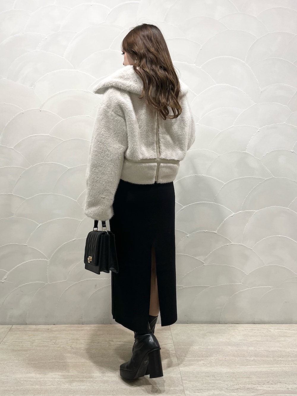 ホワイト系のその他アウター、ブラック系のワンピース、ブラック系のショルダーバッグを着用したレディースの秋コーディネートの2枚目の写真