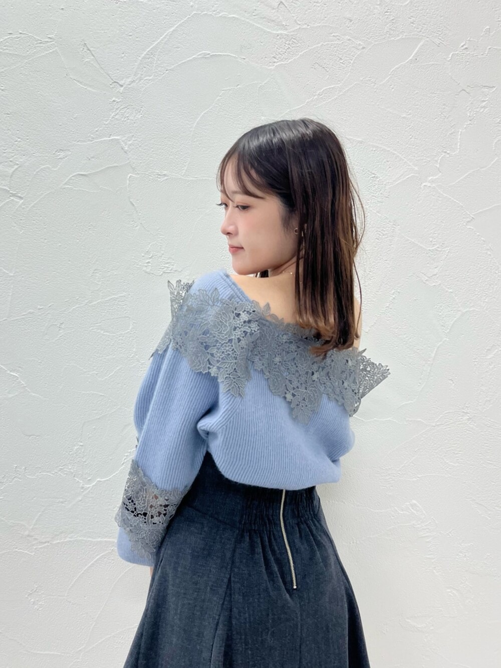 ベージュ系のブーツ、ブラック系のダウンジャケット/コート、ブルー系のニット/セーターを着用したレディースの秋コーディネートの4枚目の写真