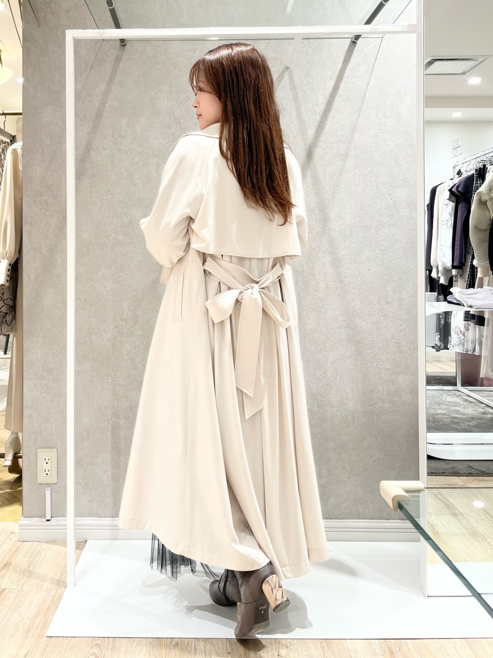 ホワイト系のトレンチコート、ブラック系のスカート、ブラック系のニット/セーターを着用したレディースの冬コーディネートの3枚目の写真