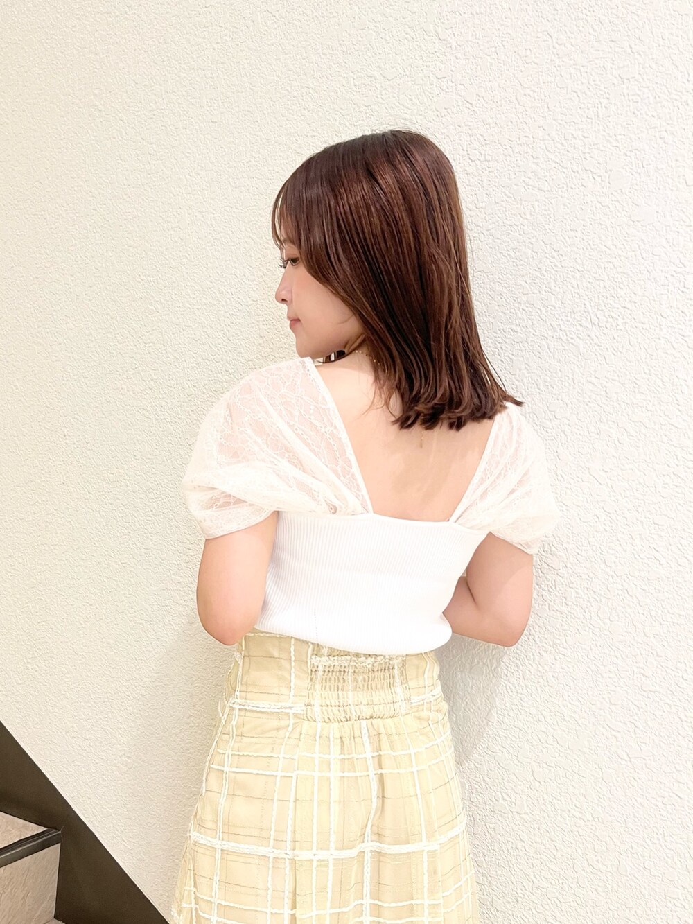 ホワイト系のニット/セーター、イエロー系のスカート、ブラック系のサンダルを着用したレディースの夏コーディネートの7枚目の写真