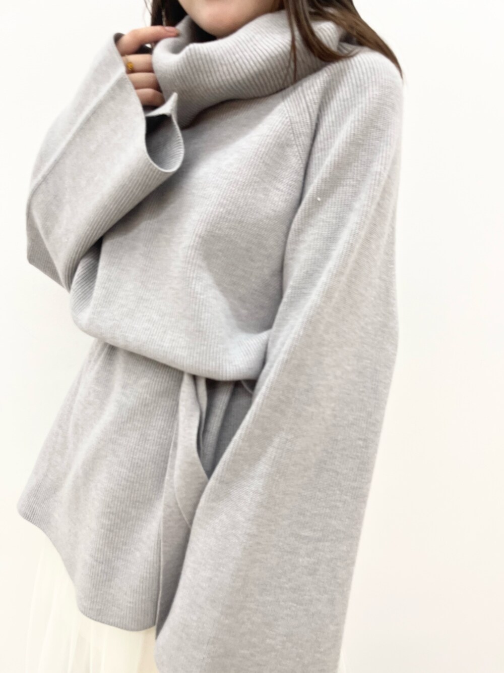 グレー系のニット/セーター、ホワイト系のスカートを着用したレディースの夏コーディネートの4枚目の写真