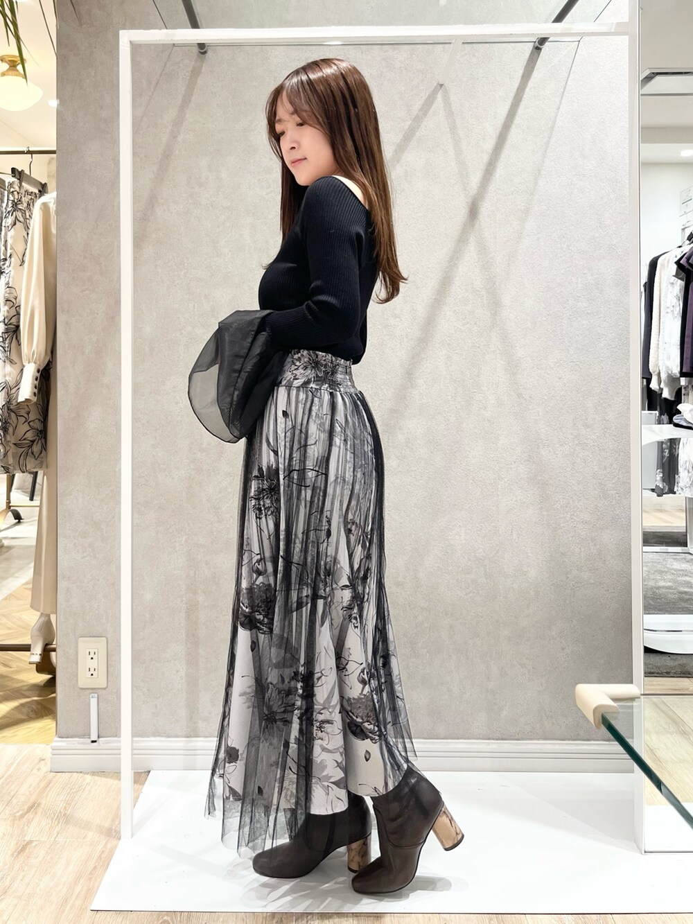 ホワイト系のトレンチコート、ブラック系のスカート、ブラック系のニット/セーターを着用したレディースの冬コーディネートの5枚目の写真