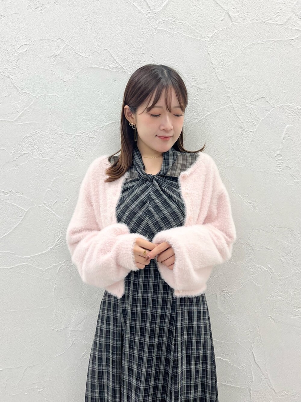 ブラック系のブーツ、ピンク系のカーディガン/ボレロ、ブラック系のワンピースを着用したレディースの秋コーディネートの2枚目の写真