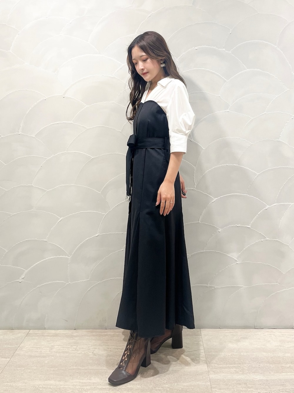 ブラック系のワンピース、レッド系のハンドバッグ、ブラウン系のブーツを着用したレディースの夏コーディネートの2枚目の写真