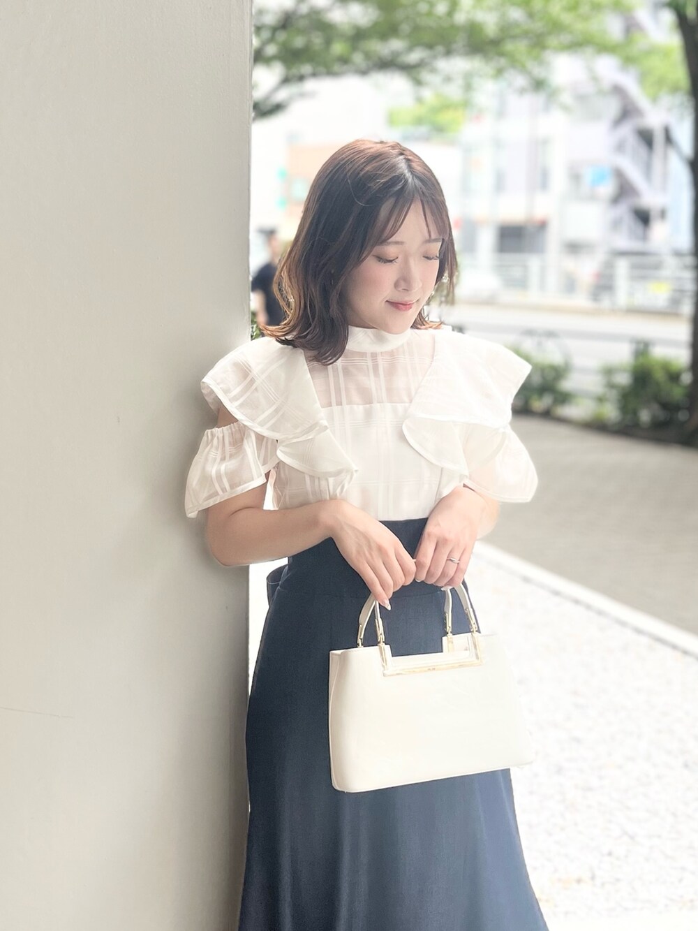 ホワイト系のワンピース、ホワイト系のハンドバッグ、ブラウン系のサンダルを着用したレディースの夏コーディネートの5枚目の写真