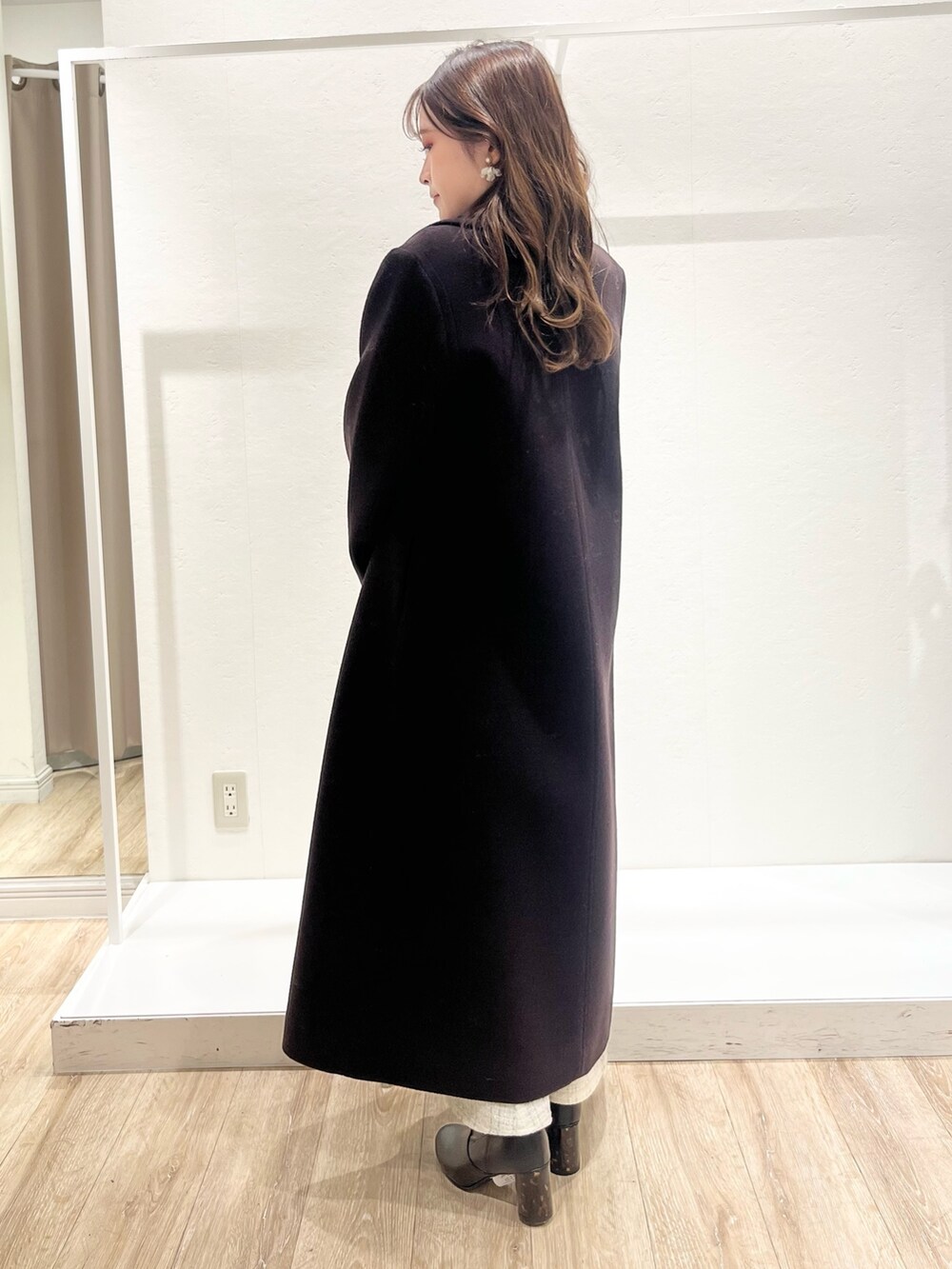 ホワイト系のワンピース、ブラウン系のチェスターコート、ホワイト系のハンドバッグを着用したレディースの秋コーディネートの3枚目の写真