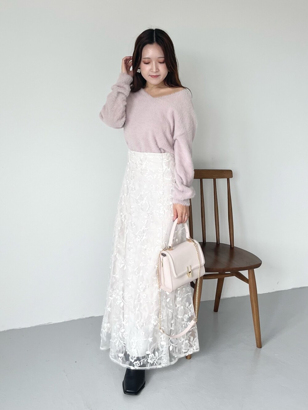ホワイト系のスカート、ピンク系のニット/セーター、ピンク系のショルダーバッグを着用したレディースの秋コーディネートの7枚目の写真