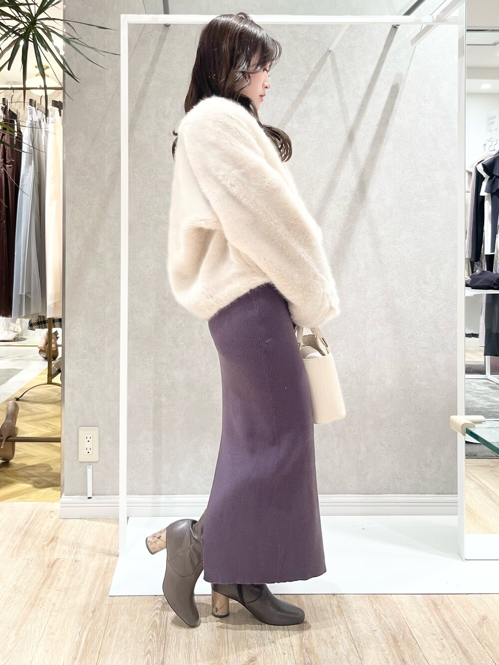 ホワイト系のその他アウター、グレー系のワンピース、ホワイト系のハンドバッグを着用したレディースの冬コーディネートの2枚目の写真