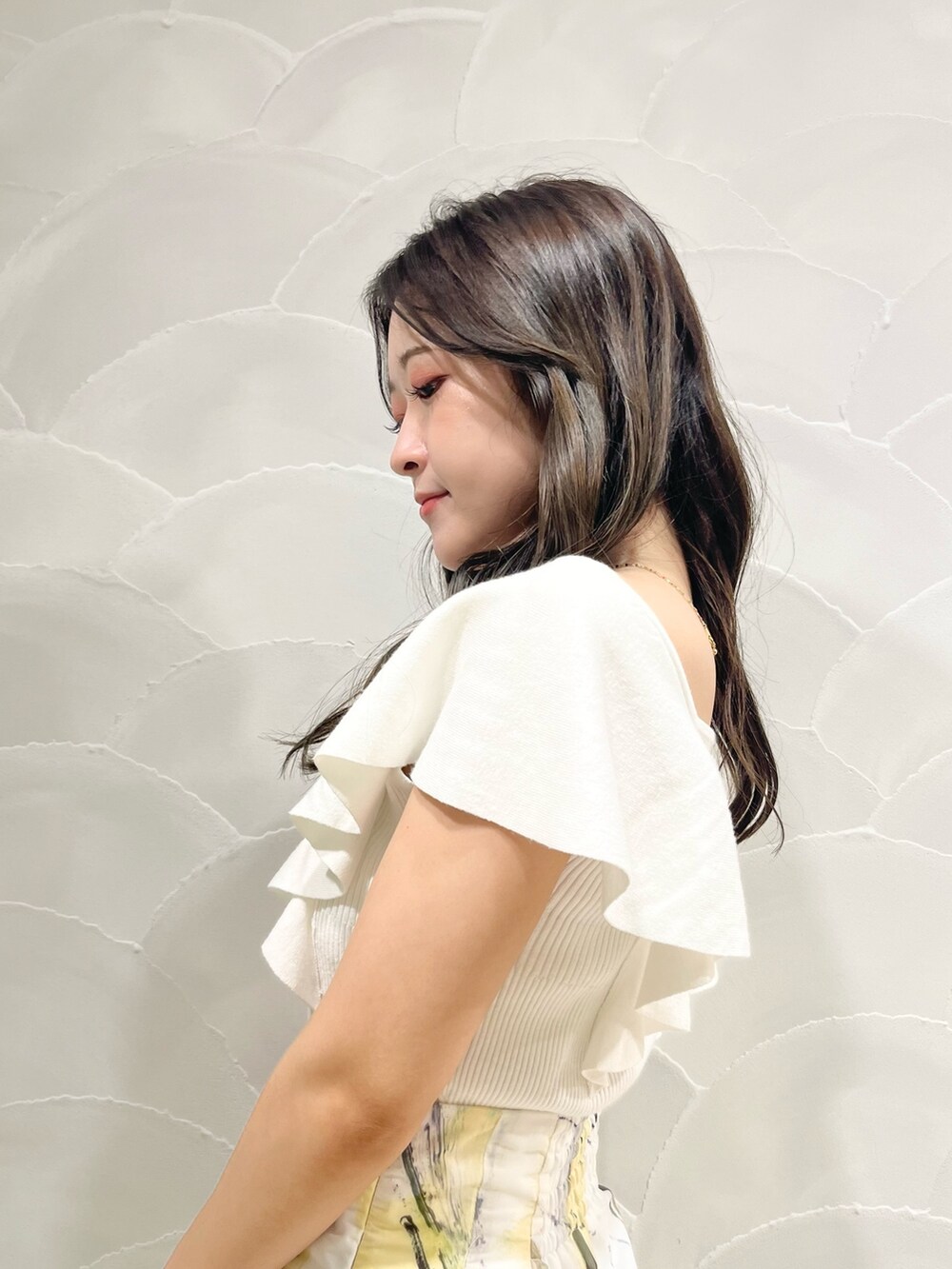 ホワイト系のニット/セーター、イエロー系のスカートを着用したレディースの夏コーディネートの6枚目の写真