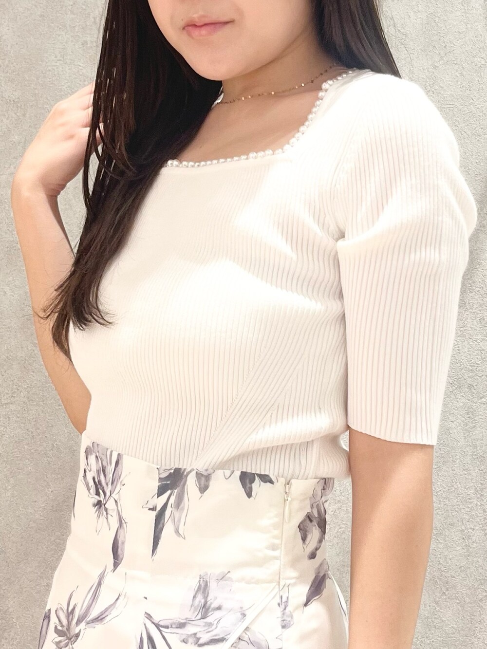 ホワイト系のニット/セーター、グレー系のスカート、ベージュ系のショルダーバッグを着用したレディースの春コーディネートの5枚目の写真