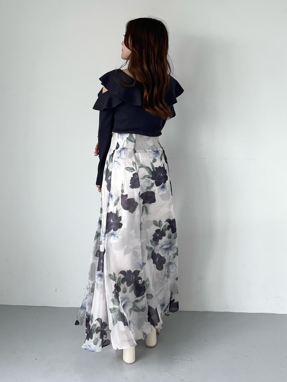 ブルー系のスカート、グレー系のニット/セーター、ホワイト系のブーツを着用したレディースの秋コーディネートの2枚目の写真