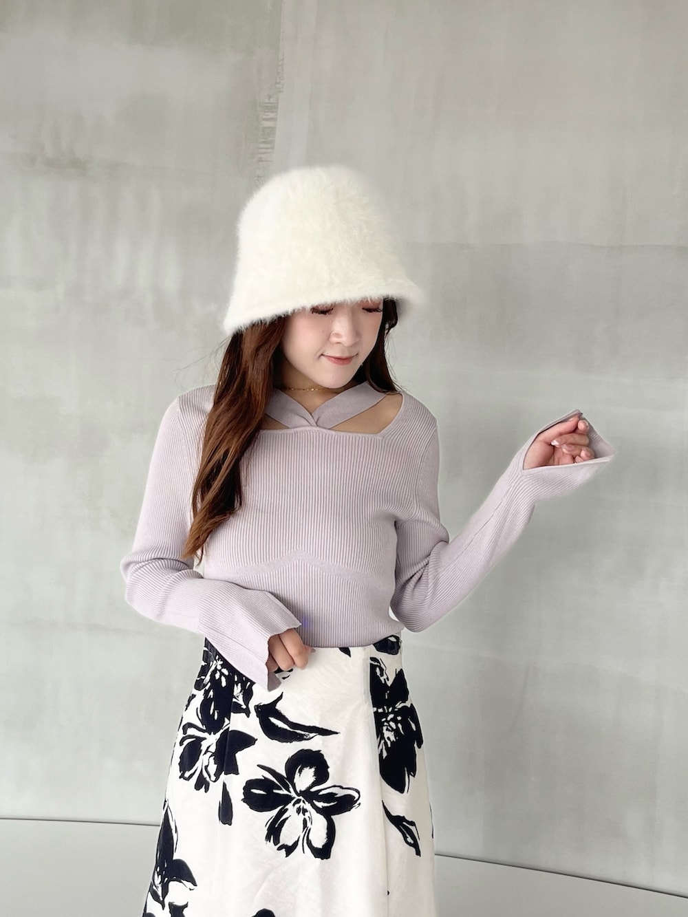 ホワイト系のスカート、パープル系のニット/セーター、ブラック系のブーツを着用したレディースの秋コーディネートの5枚目の写真