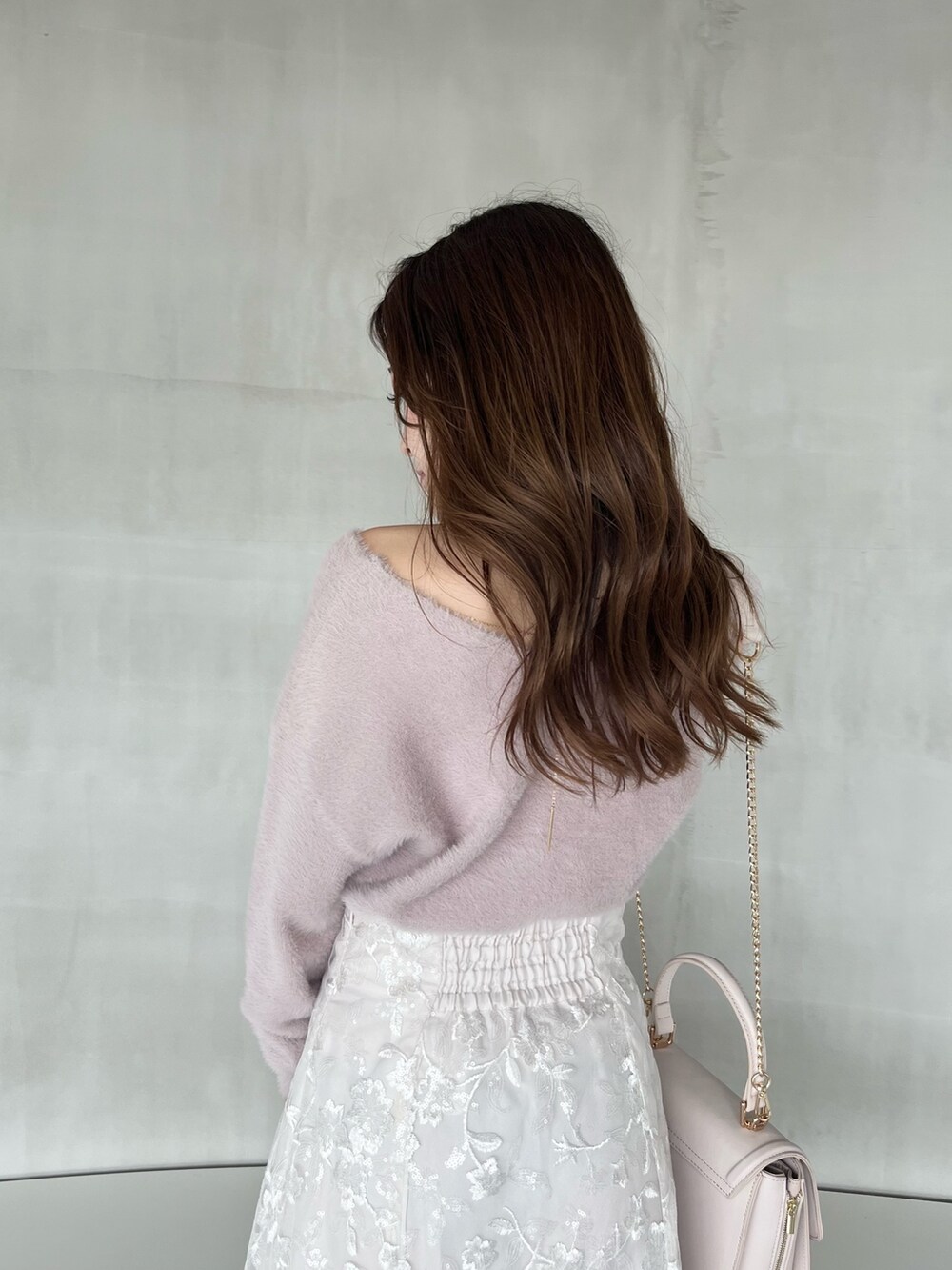 ホワイト系のスカート、ピンク系のニット/セーター、ピンク系のショルダーバッグを着用したレディースの秋コーディネートの5枚目の写真