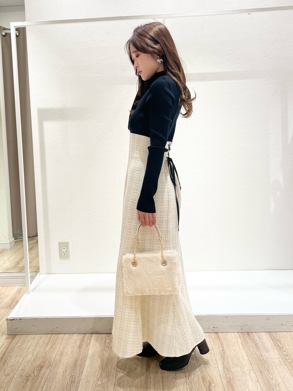 ホワイト系のワンピース、ブラウン系のチェスターコート、ホワイト系のハンドバッグを着用したレディースの秋コーディネートの6枚目の写真