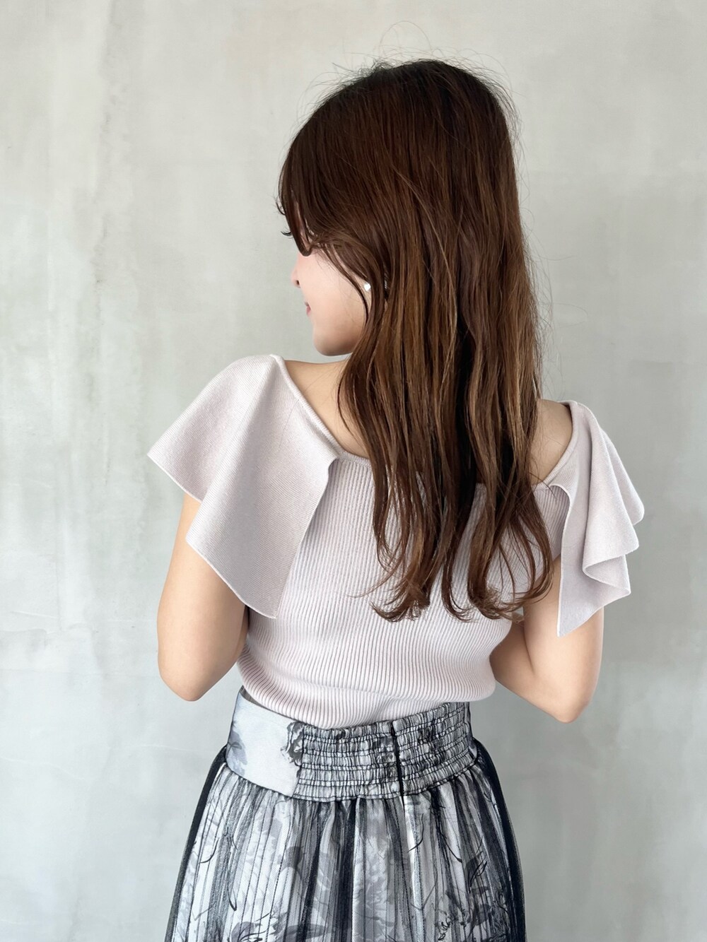 ブラック系のスカート、ピンク系のニット/セーター、ブラウン系のブーツを着用したレディースの春コーディネートの6枚目の写真