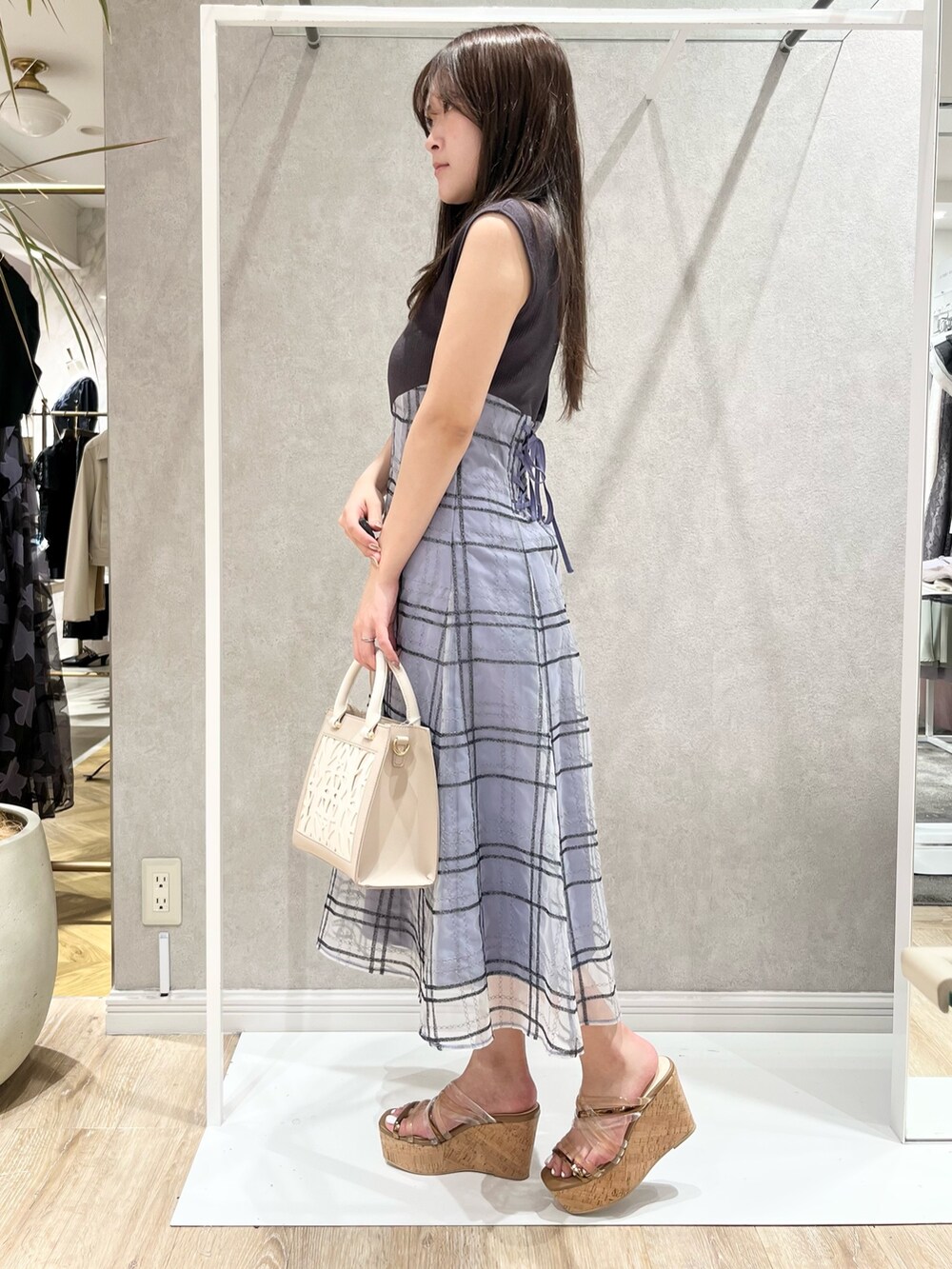 グレー系のワンピース、ベージュ系のショルダーバッグ、ブラウン系のサンダルを着用したレディースの春コーディネートの3枚目の写真