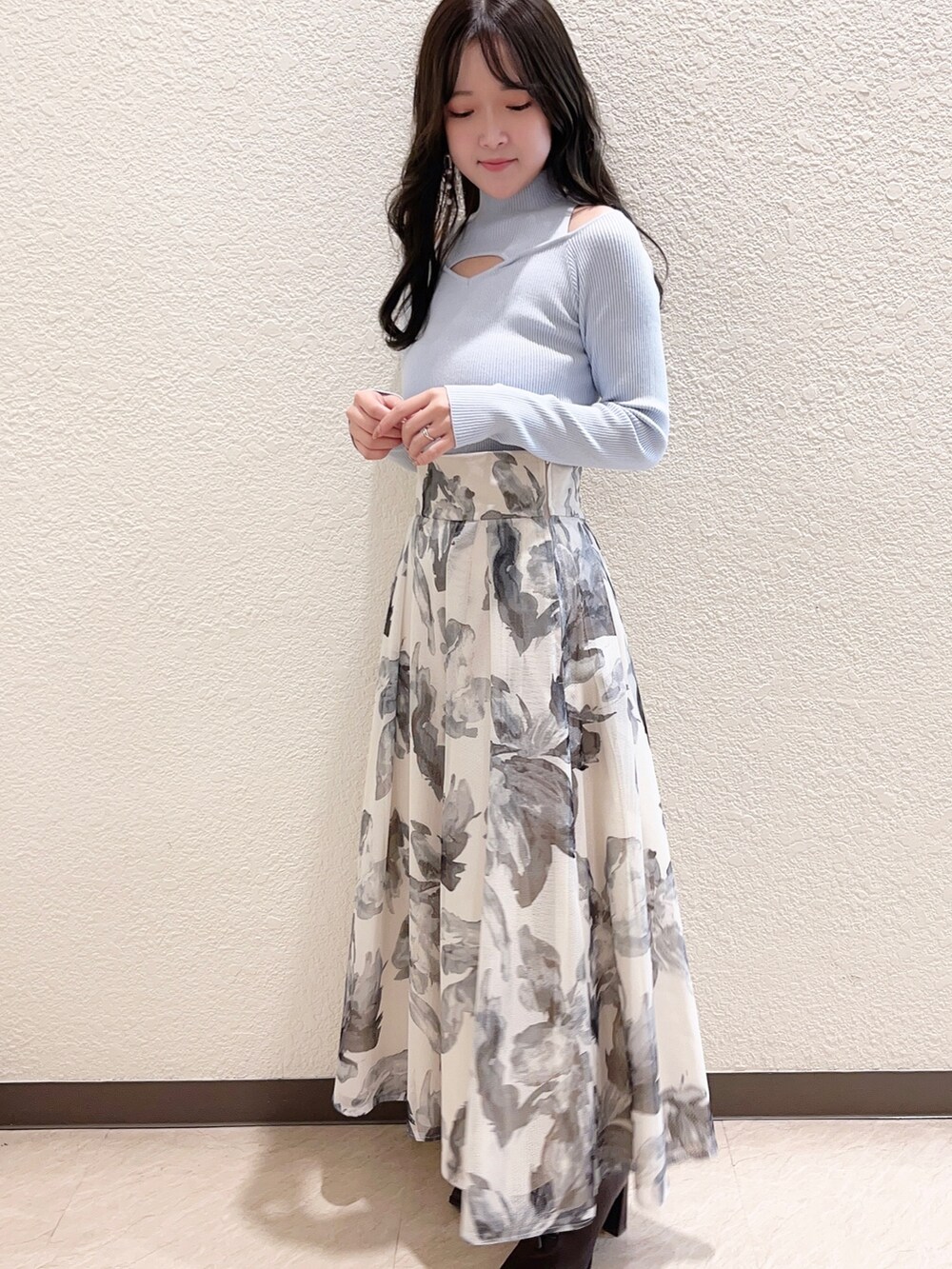 ホワイト系のスカート、ベージュ系のライダースジャケット、ブルー系のニット/セーターを着用したレディースの冬コーディネートの2枚目の写真