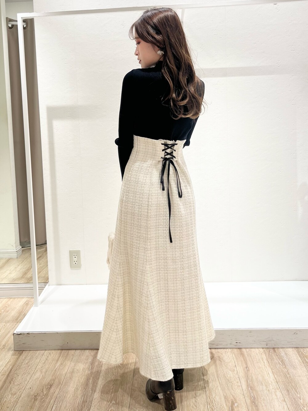 ホワイト系のワンピース、ブラウン系のチェスターコート、ホワイト系のハンドバッグを着用したレディースの秋コーディネートの7枚目の写真