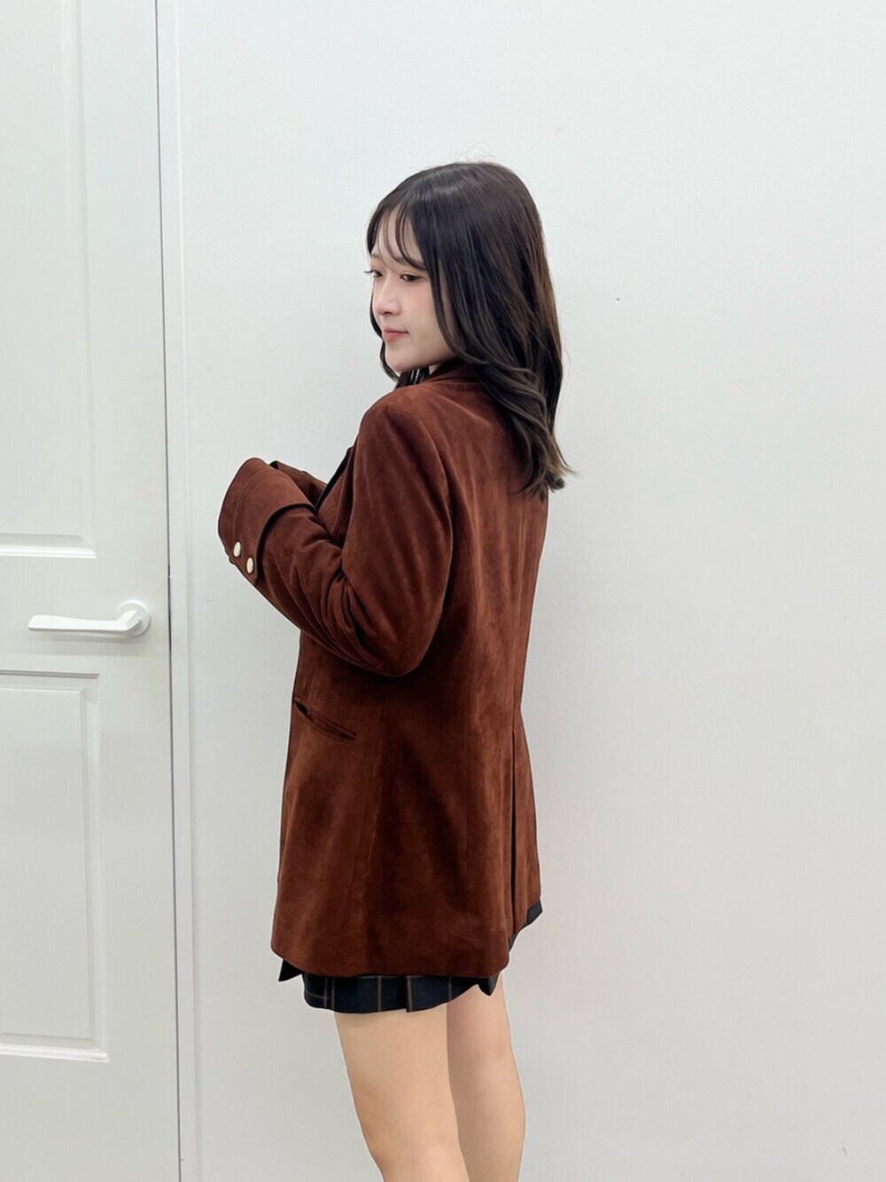 ブラウン系のテーラードジャケット、グリーン系のスカートを着用したレディースの秋コーディネートの5枚目の写真