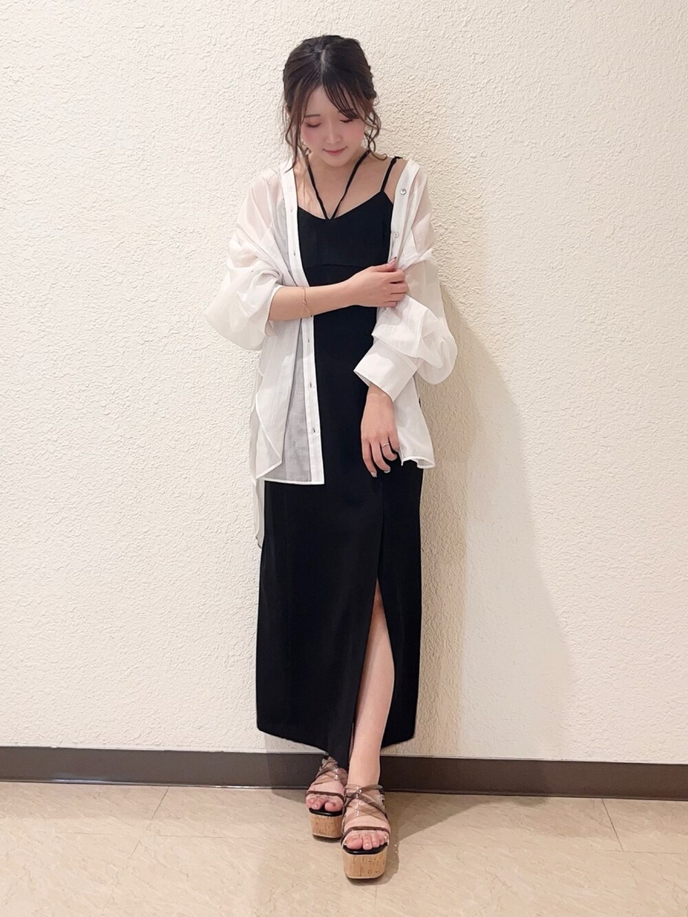 ブラック系のワンピース、ブラック系のサンダル、ホワイト系のシャツ/ブラウスを着用したレディースの春コーディネートの4枚目の写真