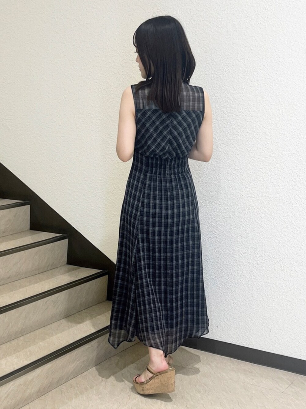 ブラウン系のサンダル、ブラック系のワンピースを着用したレディースの夏コーディネートの3枚目の写真