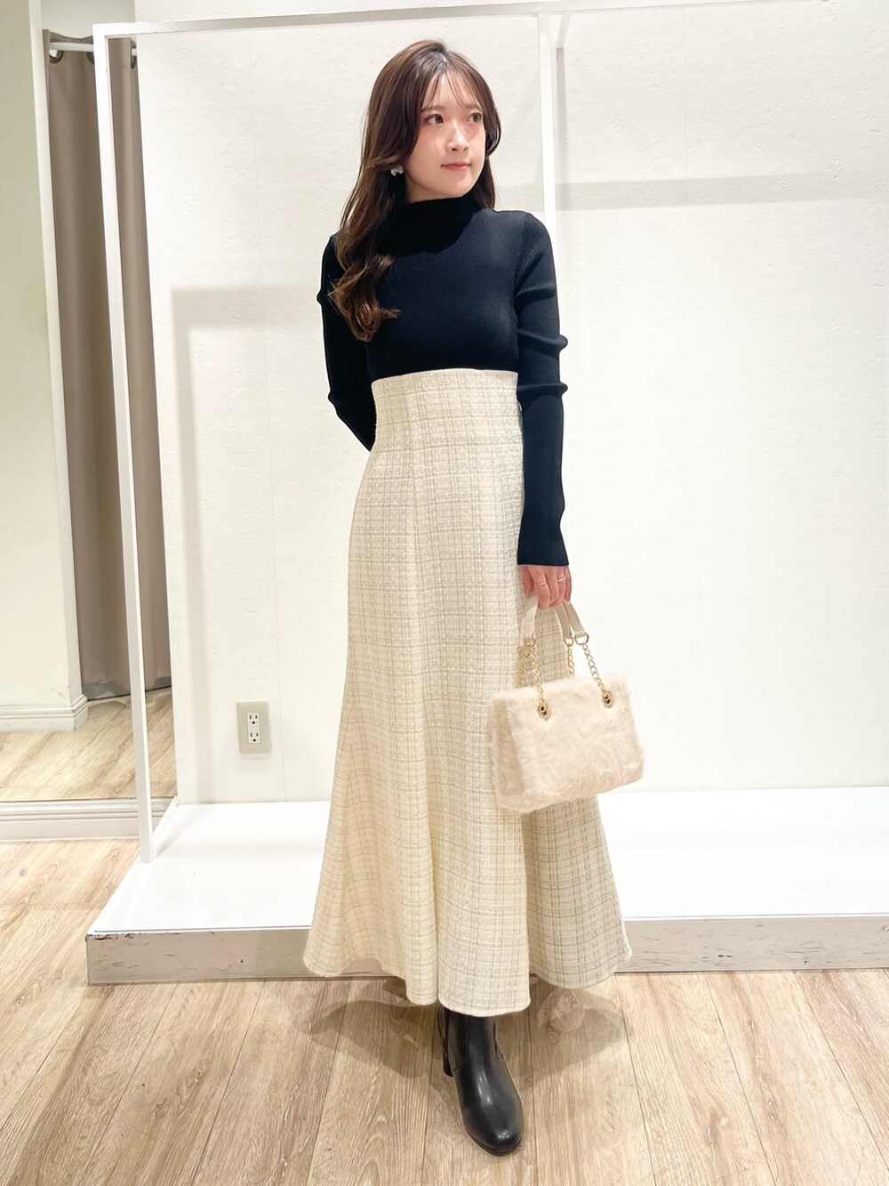 ホワイト系のワンピース、ブラウン系のチェスターコート、ホワイト系のハンドバッグを着用したレディースの秋コーディネートの4枚目の写真