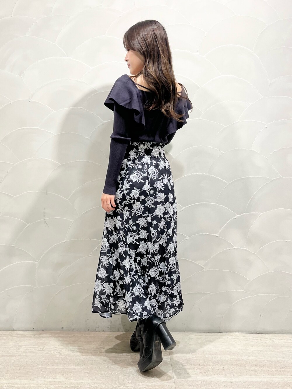 ホワイト系のダウンジャケット/コート、グレー系のスカート、グレー系のニット/セーターを着用したレディースの冬コーディネートの5枚目の写真