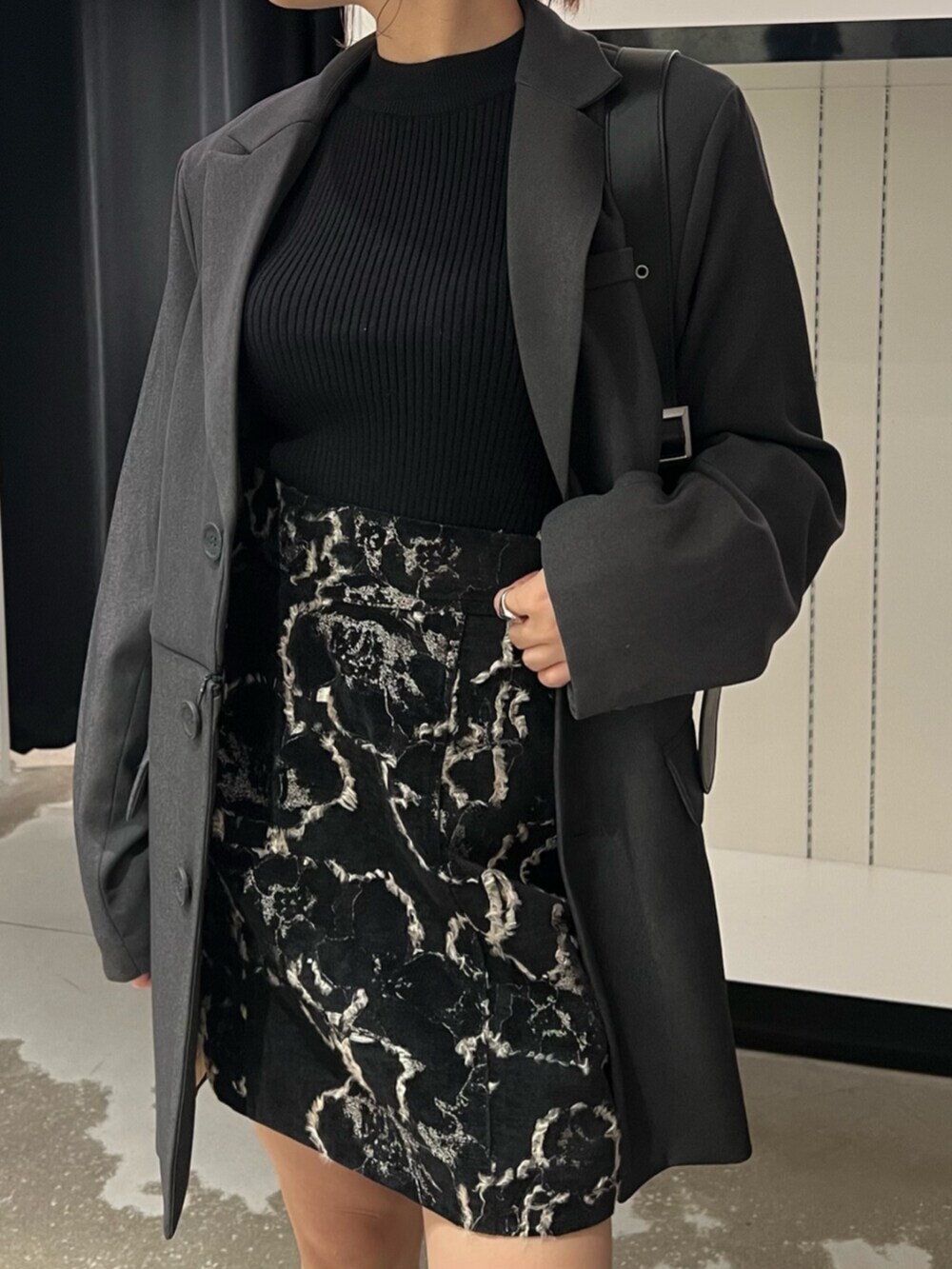 ブラック系のハンドバッグ、ブラウン系のブーツ、ブラック系のニット/セーターを着用したレディースの秋コーディネートの7枚目の写真