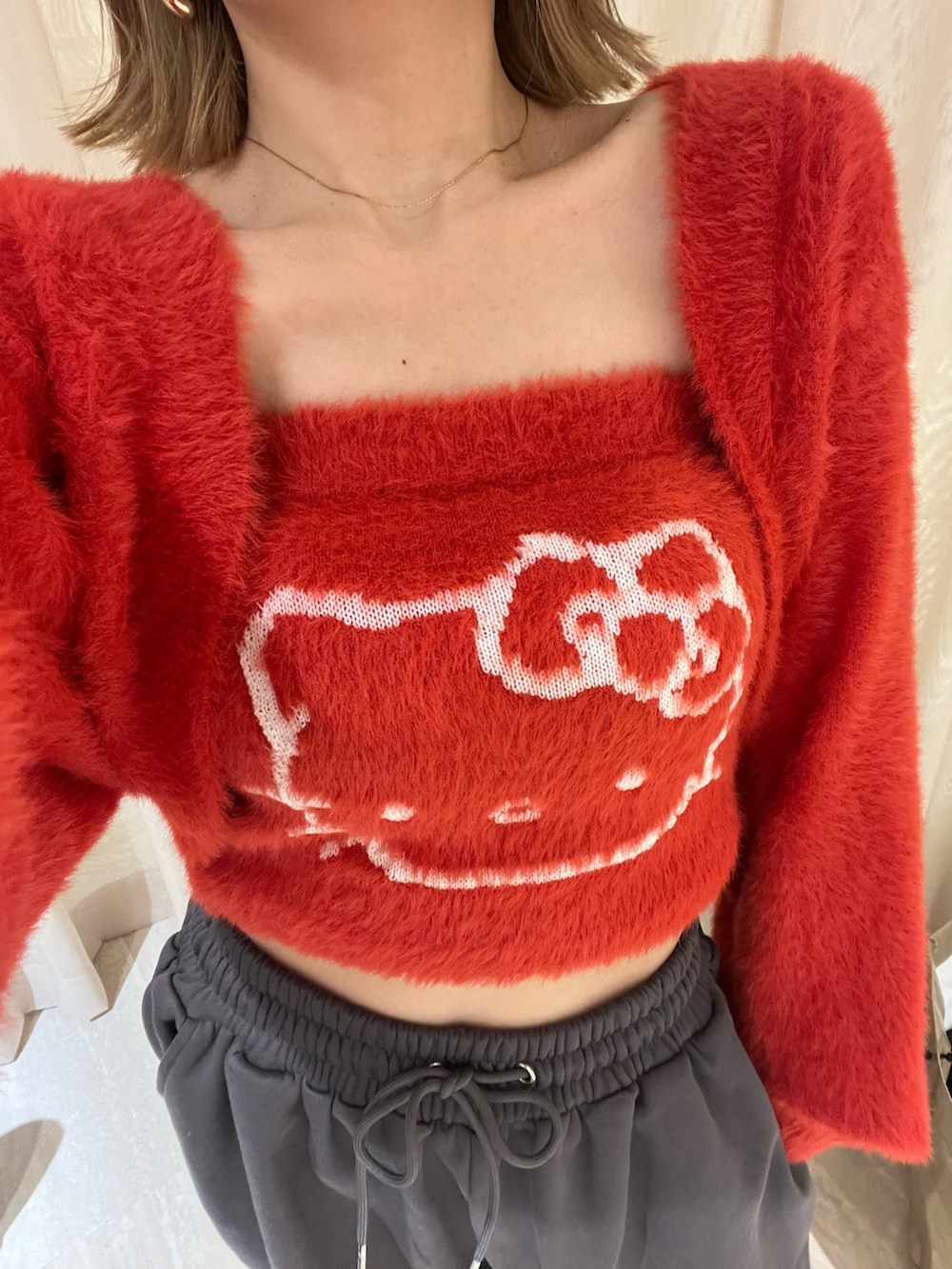 レッド系のニット/セーター、グレー系のその他パンツを着用したレディースの冬コーディネートの6枚目の写真