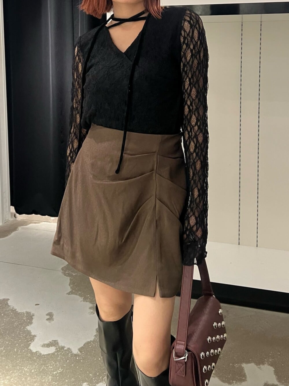 ブラック系のTシャツ/カットソー、ブラウン系のスカート、ブラック系のブーツを着用したレディースの秋コーディネートの7枚目の写真