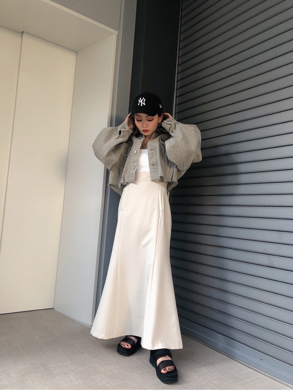 ホワイト系のキャミソール、ベージュ系のデニムジャケットを着用したレディースの春コーディネートの2枚目の写真