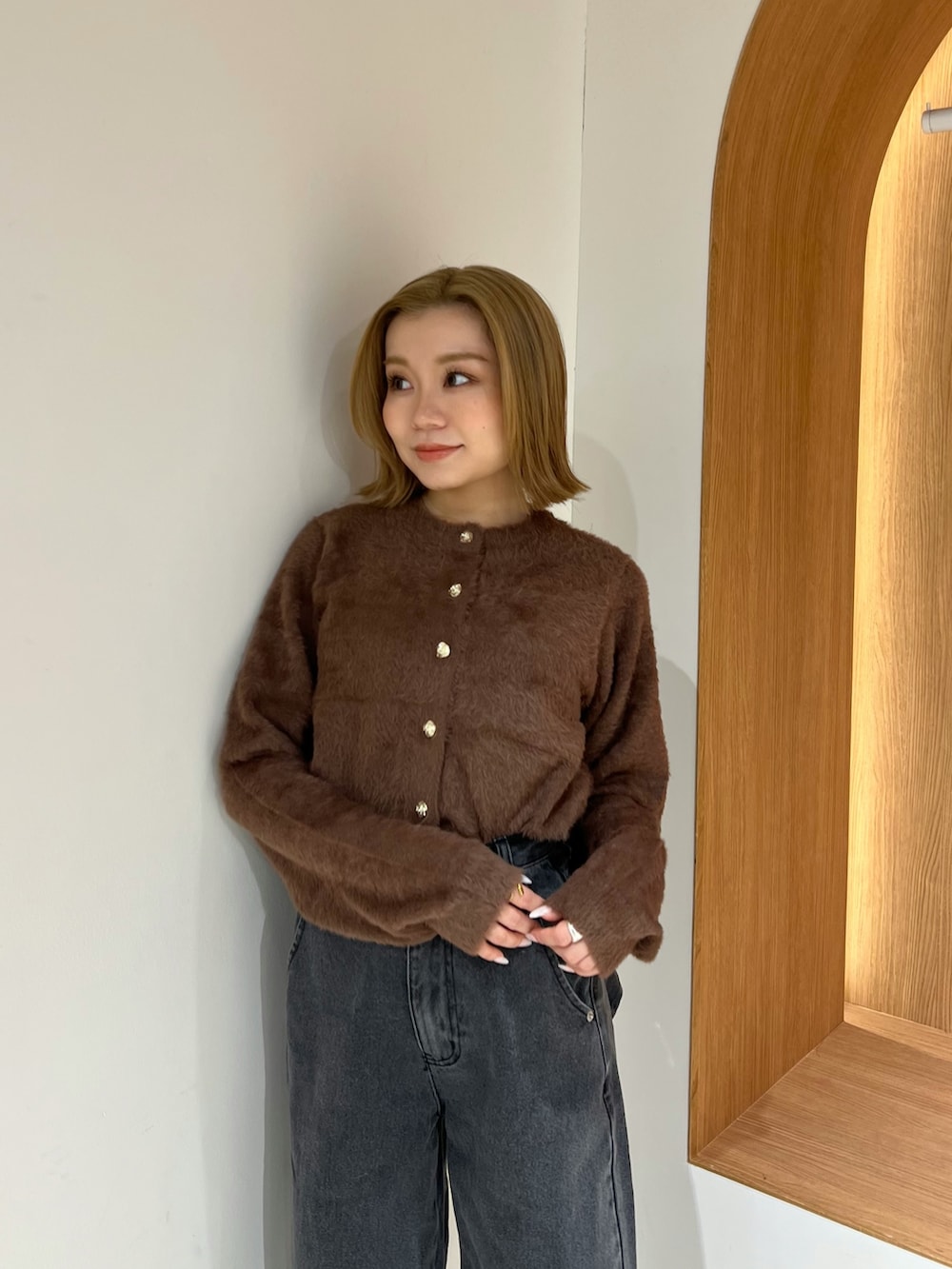 ブラウン系のカーディガン/ボレロ、ブラック系のデニムパンツ、ブラウン系のブーツを着用したレディースの冬コーディネートの4枚目の写真