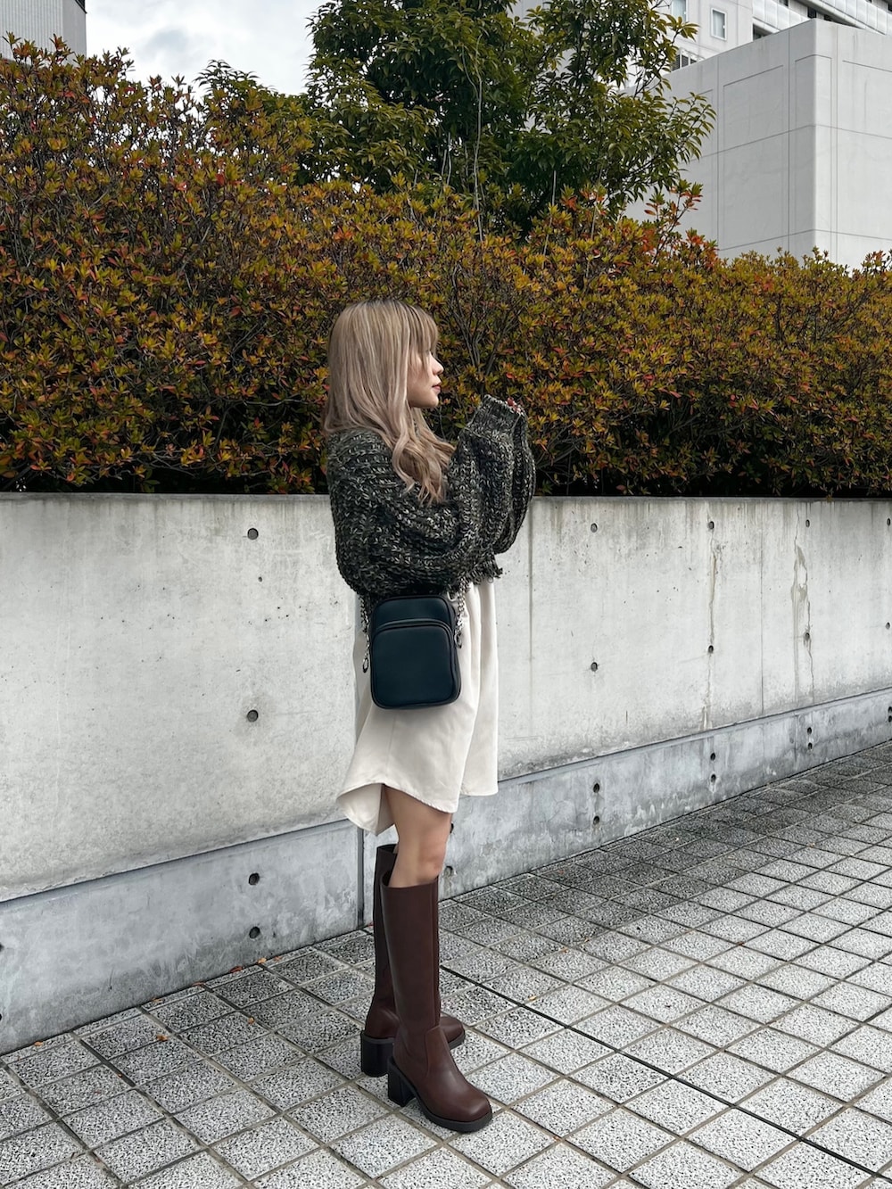 グリーン系のワンピース、ブラック系のショルダーバッグ、ブラウン系のブーツを着用したレディースの冬コーディネートの2枚目の写真