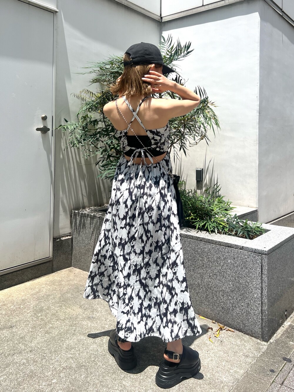 ホワイト系のワンピース、ブラック系のショルダーバッグ、ブラック系のサンダルを着用したレディースの夏コーディネートの3枚目の写真