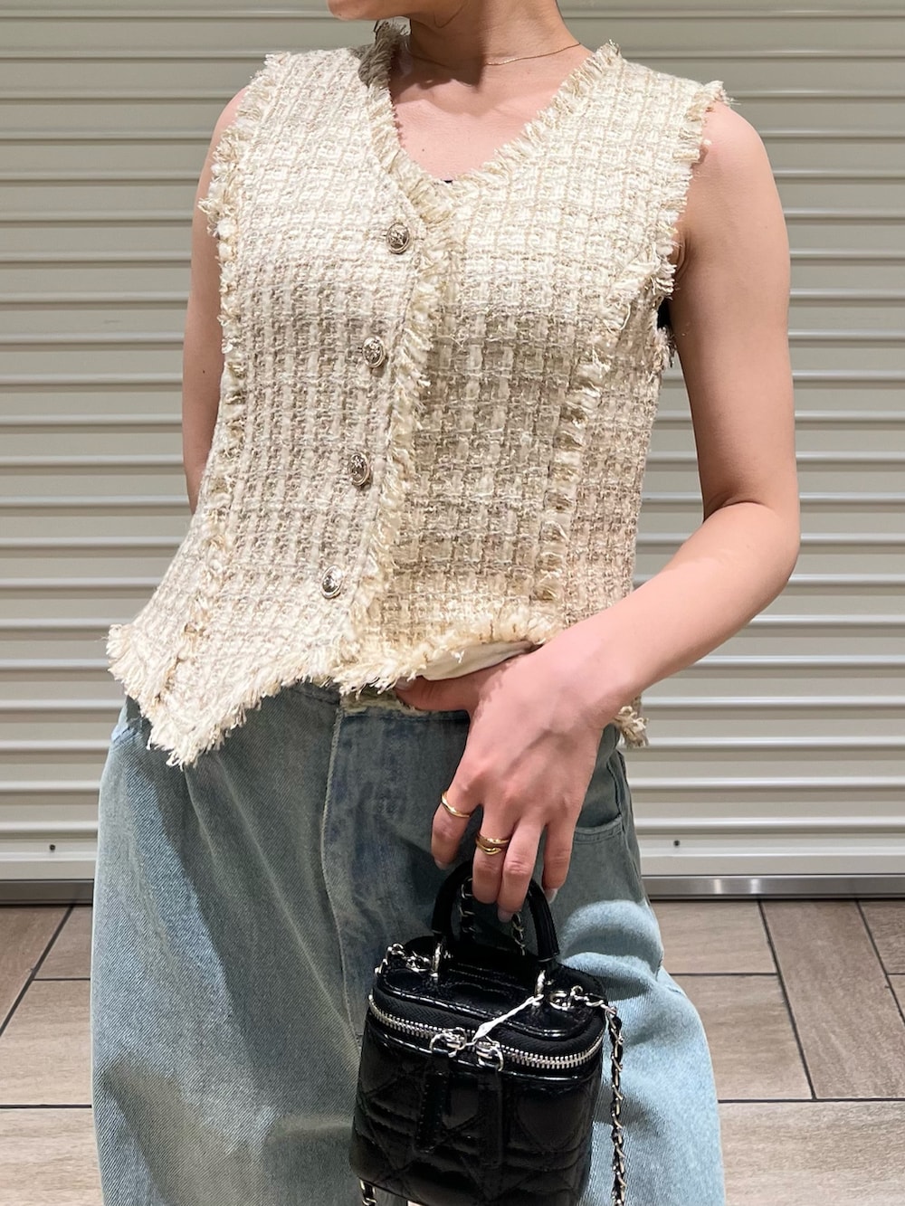 ベージュ系のベスト、ブルー系のデニムパンツを着用したレディースの夏コーディネートの6枚目の写真