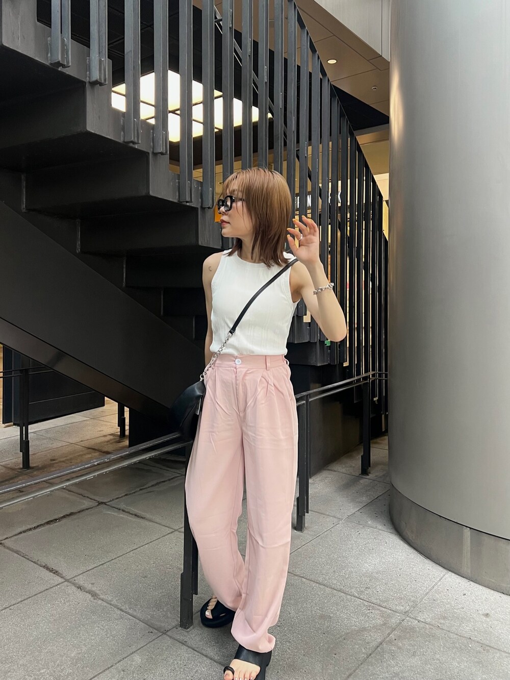 ブラック系のサンダル、ブラック系のハンドバッグ、ホワイト系のTシャツ/カットソーを着用したレディースの夏コーディネートの3枚目の写真