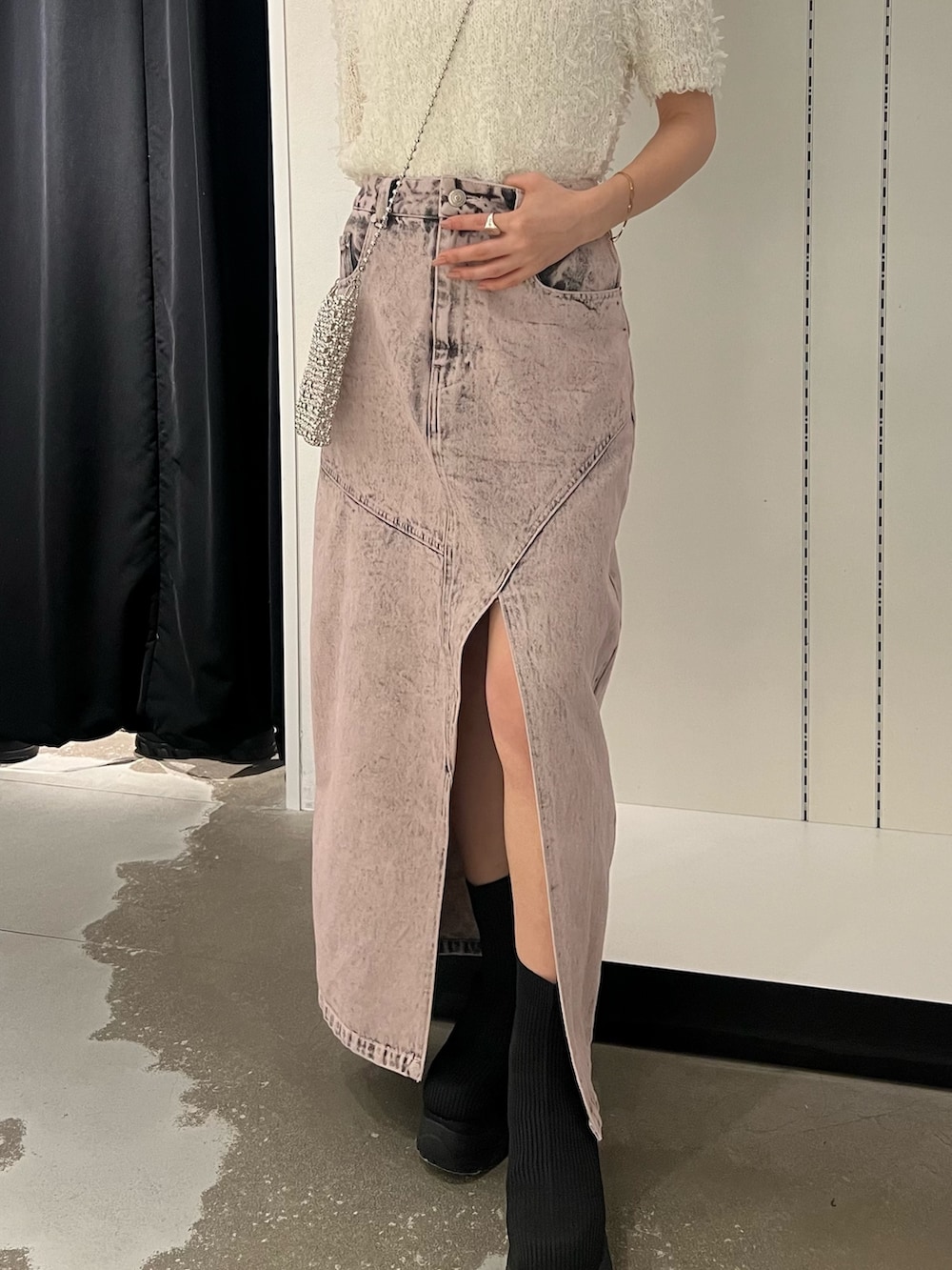 ホワイト系のニット/セーター、ピンク系のデニムスカート、ブラック系のブーツを着用したレディースの春コーディネートの7枚目の写真