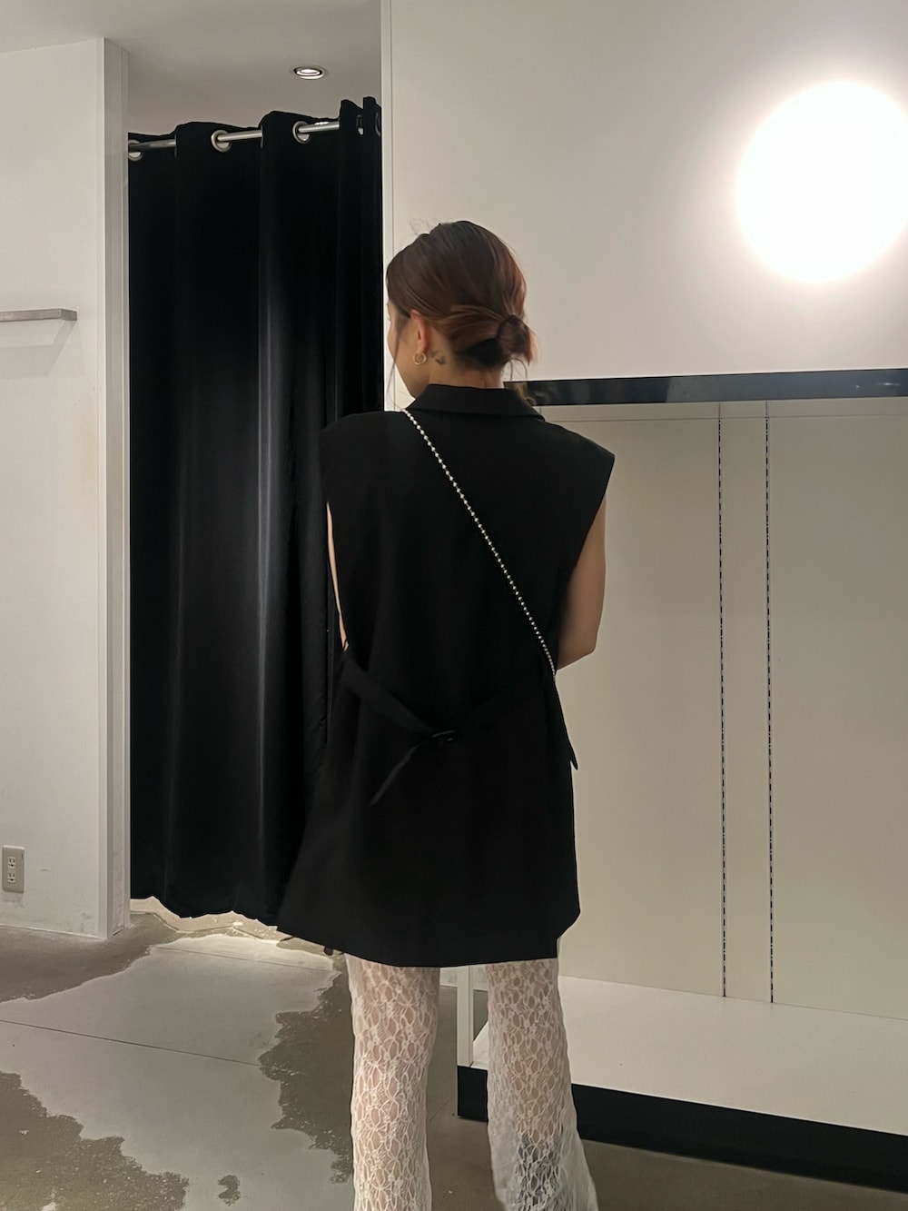 ブラック系のベスト、ホワイト系のその他パンツ、ブラック系のサンダルを着用したレディースの春コーディネートの5枚目の写真