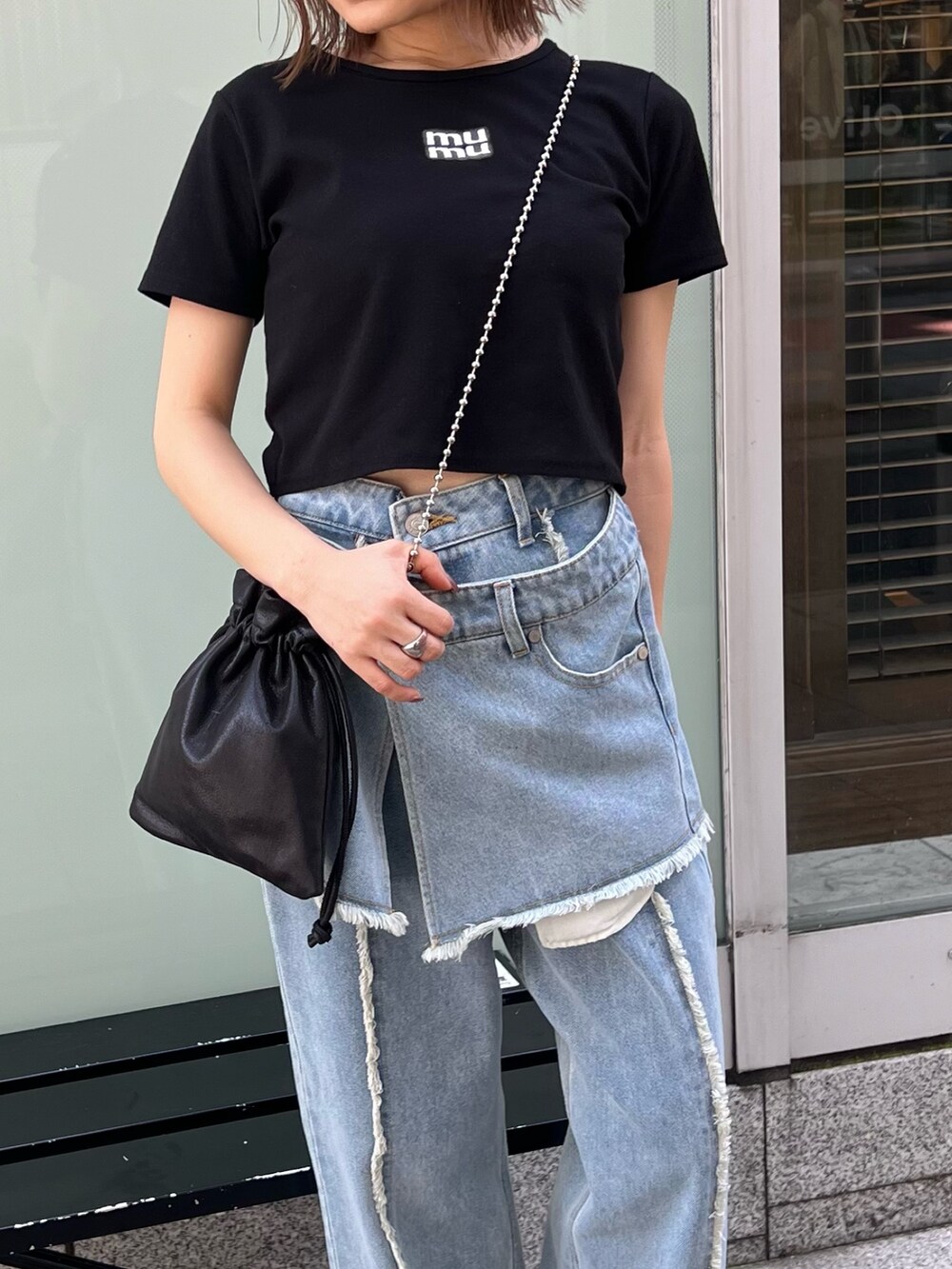 ブラック系のTシャツ/カットソー、ブルー系のデニムパンツ、ブラック系のショルダーバッグを着用したレディースの夏コーディネートの6枚目の写真