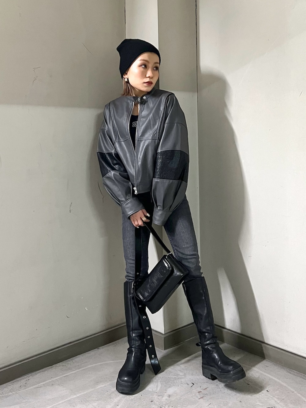 グレー系のブルゾン、ブラック系のTシャツ/カットソー、ブラック系のショルダーバッグを着用したレディースの冬コーディネートの4枚目の写真