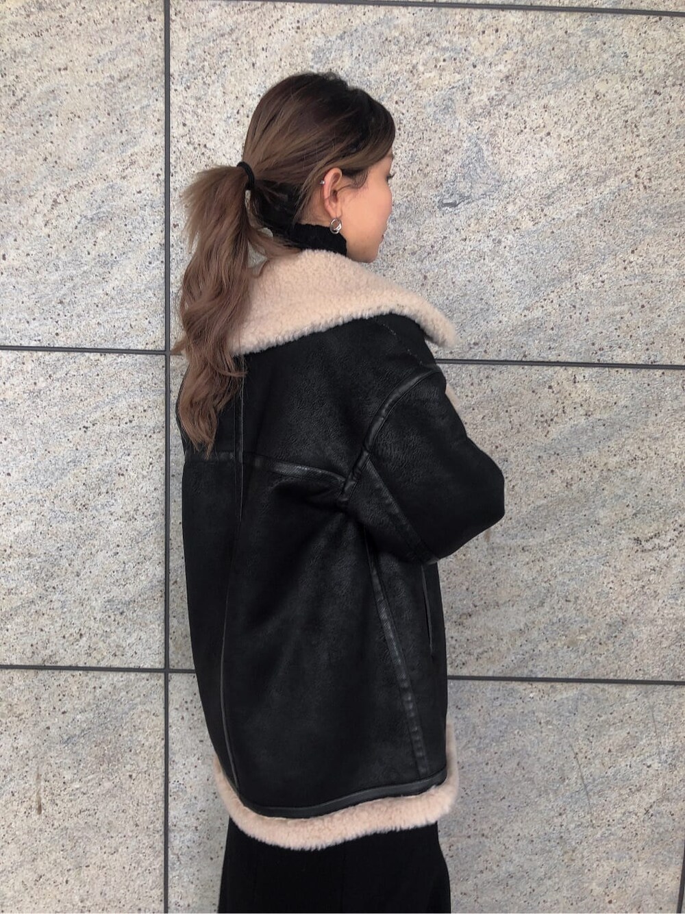 ブラック系のスカート、ブラック系のブルゾン、ブラック系のブーツを着用したレディースの秋コーディネートの3枚目の写真