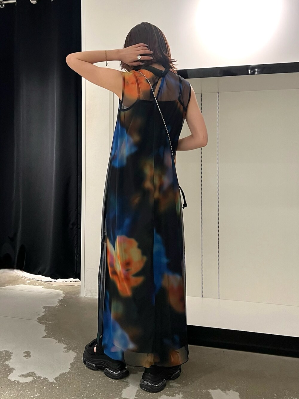 ブラック系のワンピース、ブラック系のサンダル、ブラック系のショルダーバッグを着用したレディースの春コーディネートの2枚目の写真