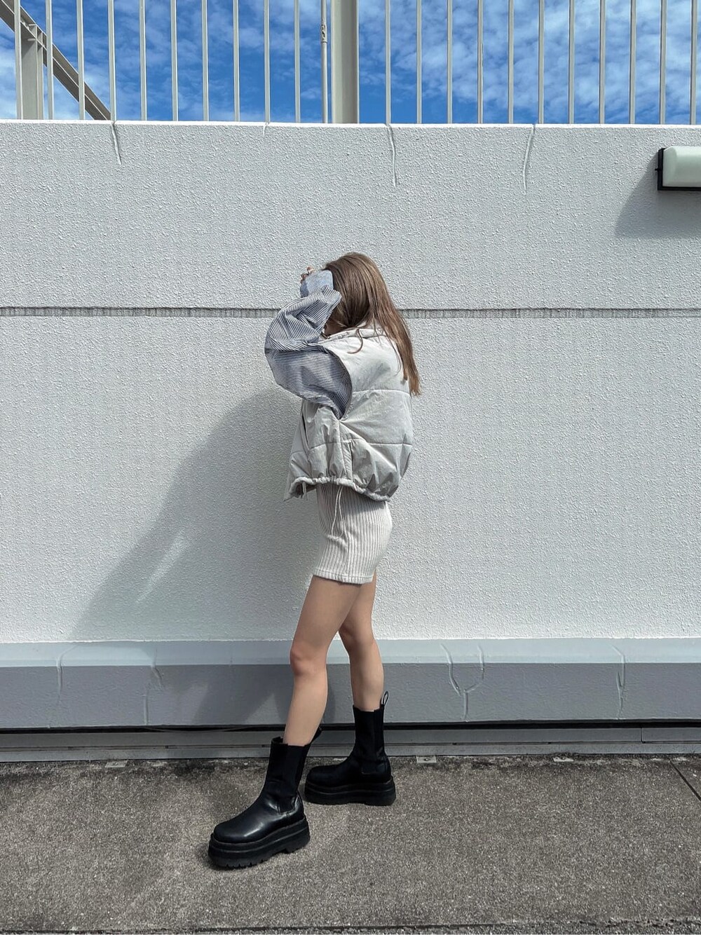 ブルー系のシャツ/ブラウス、ホワイト系のダウンベストを着用したレディースの秋コーディネートの5枚目の写真