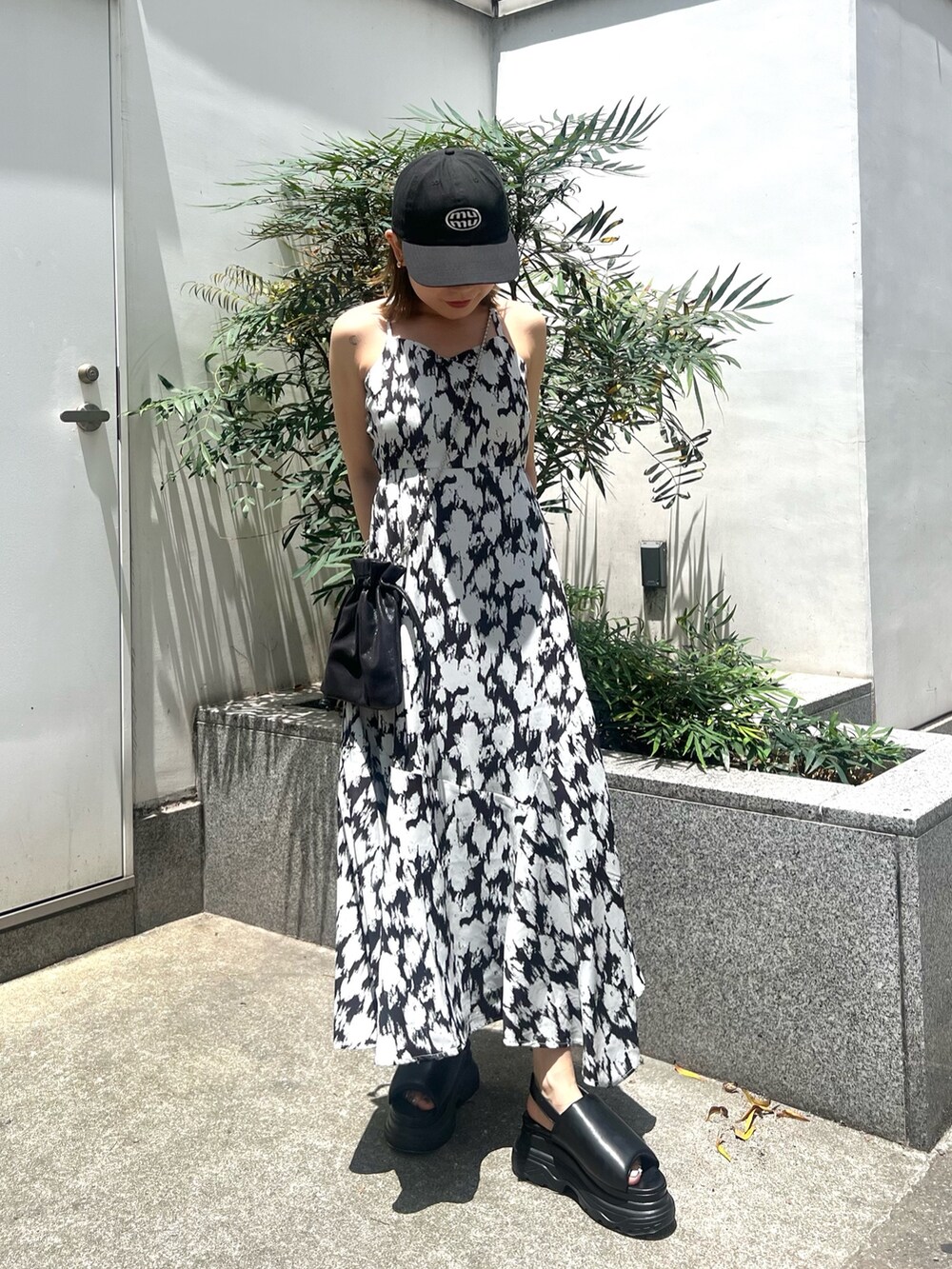 ホワイト系のワンピース、ブラック系のショルダーバッグ、ブラック系のサンダルを着用したレディースの夏コーディネートの4枚目の写真