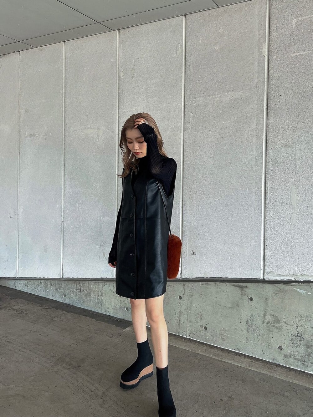 ブラック系のニット/セーター、ブラウン系のショルダーバッグ、ブラック系のワンピースを着用したレディースの秋コーディネートの2枚目の写真