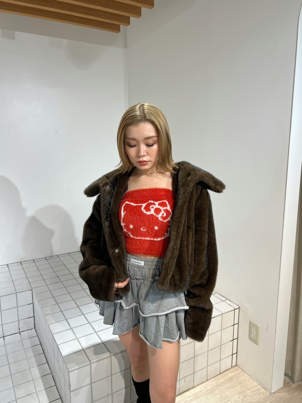 レッド系のニット/セーター、ブラウン系のブルゾン、グレー系のその他パンツを着用したレディースの冬コーディネートの4枚目の写真