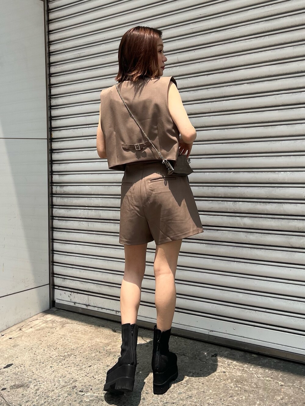 ブラック系のサンダル、ブラック系のショルダーバッグ、ブラウン系のその他パンツを着用したレディースの夏コーディネートの2枚目の写真