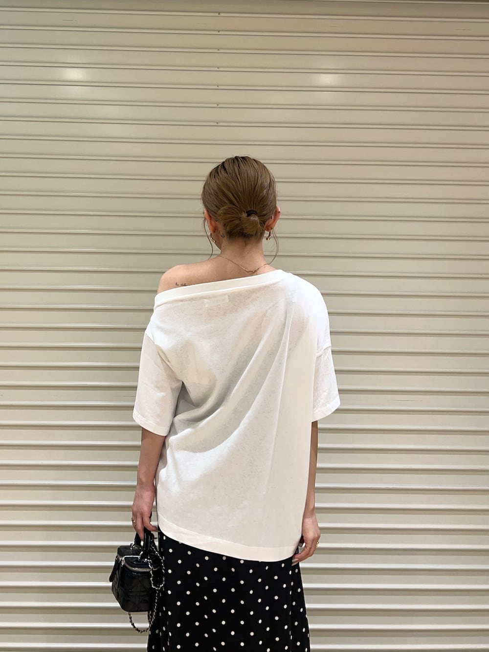 ホワイト系のTシャツ/カットソー、ブラック系のスカートを着用したレディースの夏コーディネートの5枚目の写真