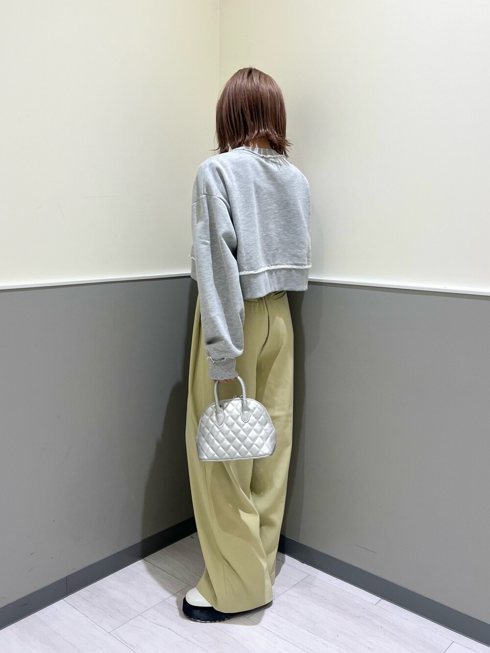 グレー系のスウェット、グリーン系のその他パンツ、シルバー系のハンドバッグを着用したレディースの冬コーディネートの2枚目の写真