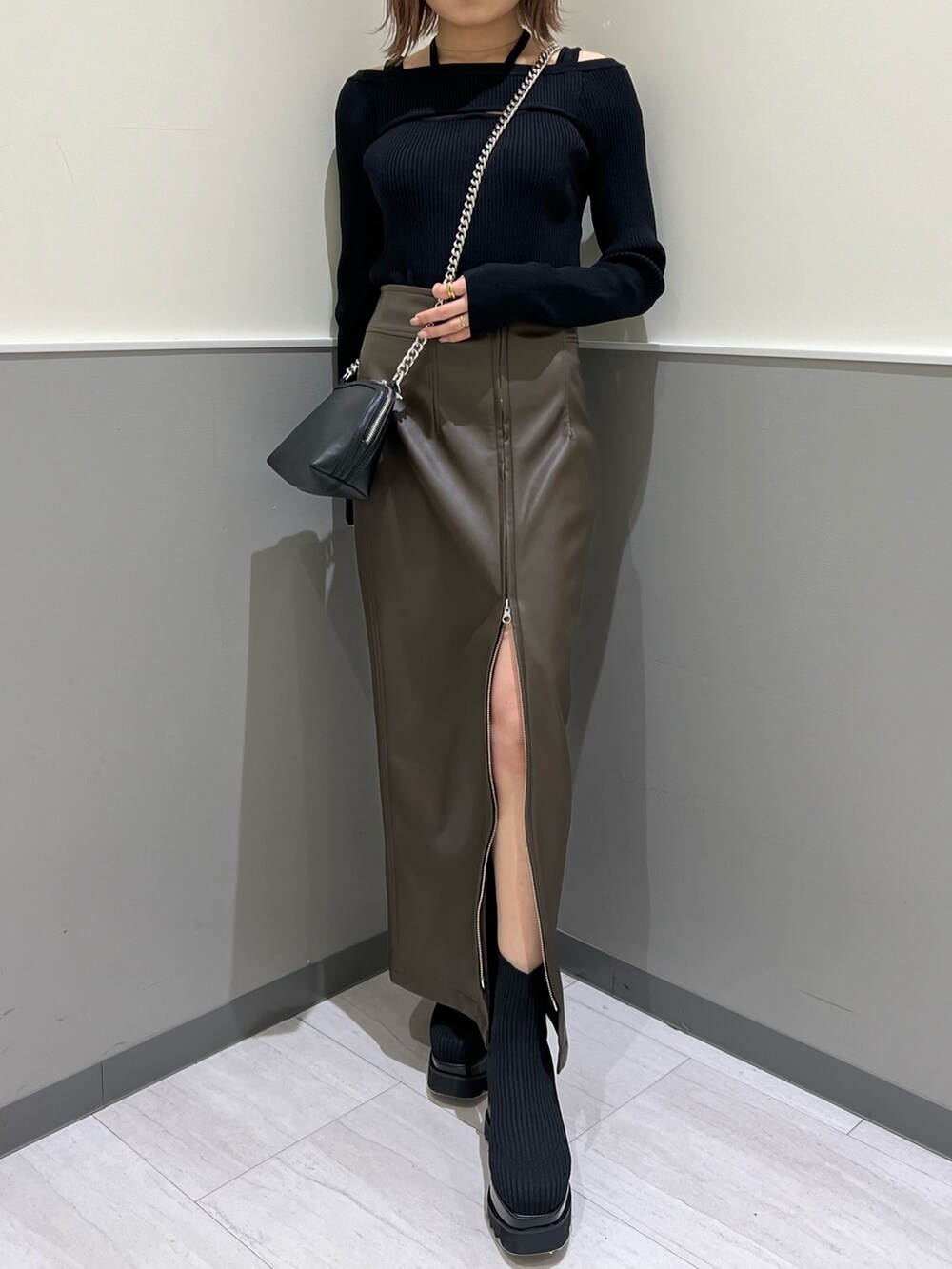 ブラック系のニット/セーター、ブラック系のブーツ、ブラウン系のスカートを着用したレディースの冬コーディネートの7枚目の写真